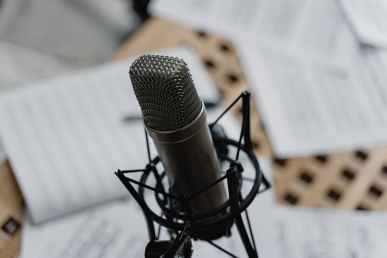 Mastering the First Impression: Your intriguing post title goes here Close-up of a condenser microphone on a mic stand surrounded by music sheets in a studio setting.